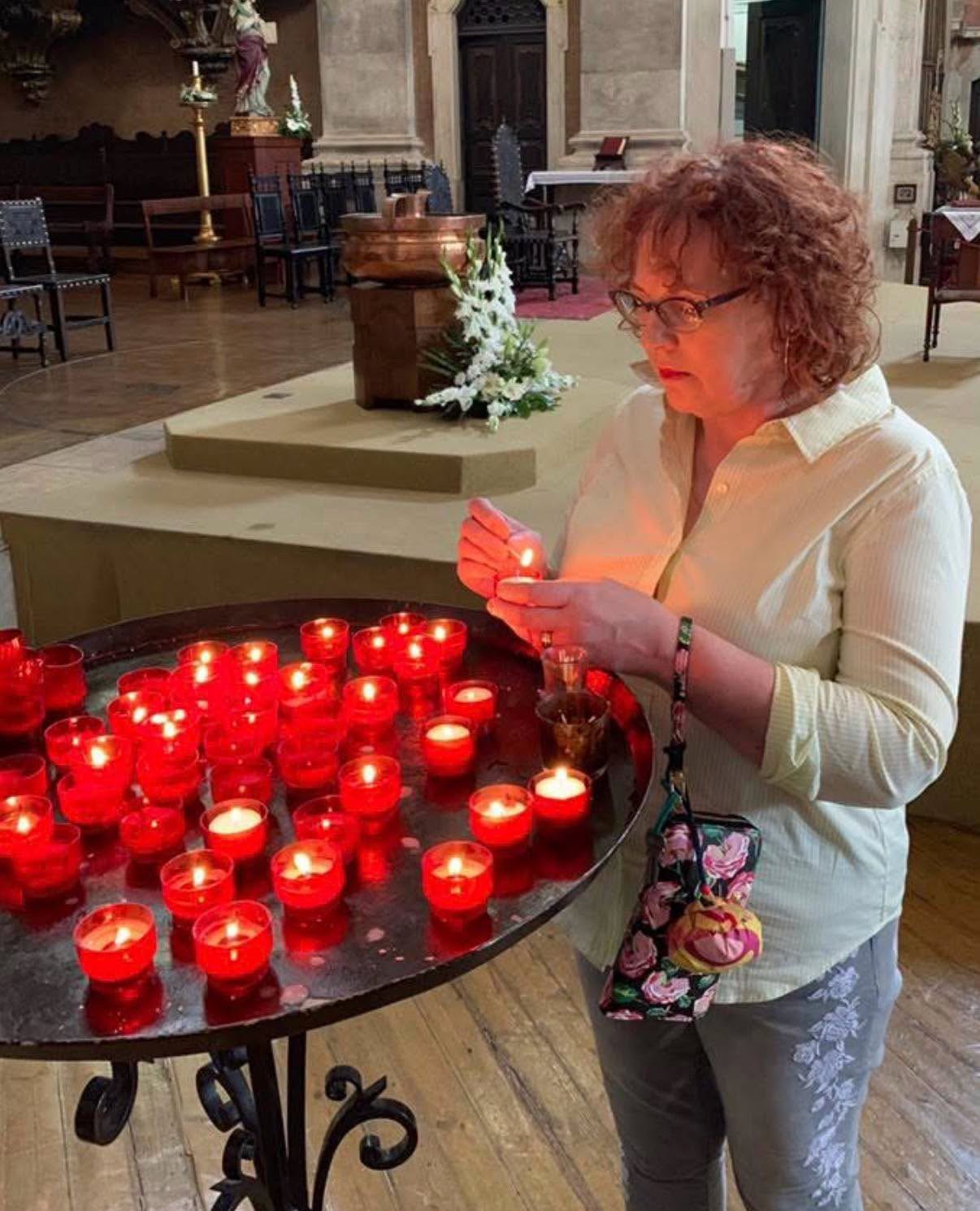 Jacqueline Fairbrass lighting a candle and saying a prayer