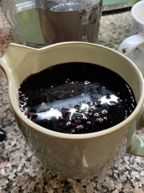 Thick elderberry syrup in a jug