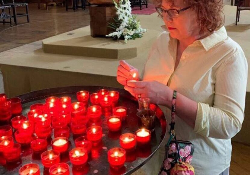 Jacqueline Fairbrass lighting a candle and saying a prayer