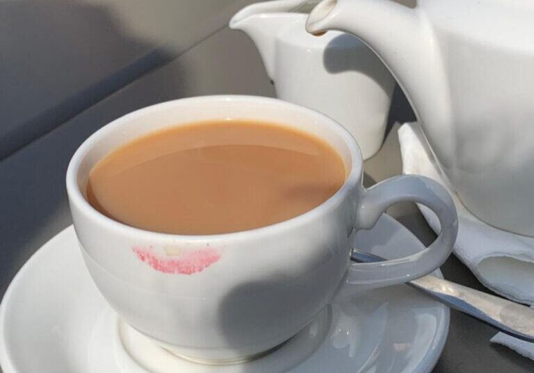 a teapot and a teacup with a lipstick mark